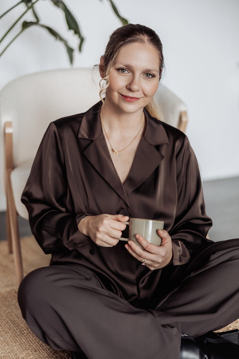 Tilly sitting with a cup of coffee, smiling.